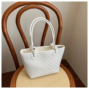 Detail of white woven tote bag texture with silver metal buckles on a vintage chair