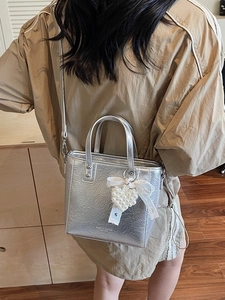 Mini sac cabas argenté effet froissé avec breloque cœur en perles et nœud vue sur modèle