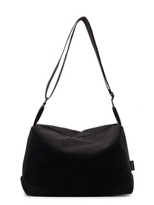 Minimalist black canvas tote bag with adjustable wide shoulder strap and brand label