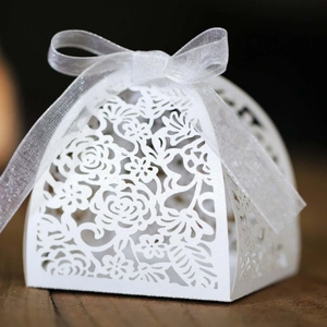 Elegant white laser-cut gift box with floral patterns and a translucent ribbon bow