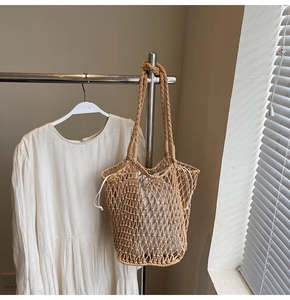 Close-up of hand-woven beige knit tote bag with drawstring lining on a hanger