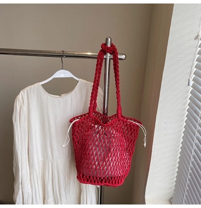 Detail of red hollow knit tote bag featuring a white drawstring canvas inner pouch