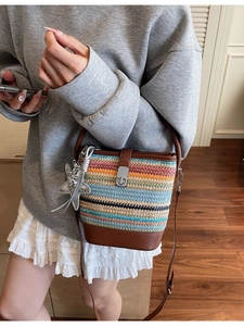 Contrast woven bucket bag with brown leather strap and silver star pendant accessory