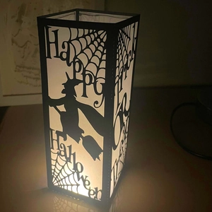 Dettaglio di sagoma di strega tagliata al laser su una lanterna di Halloween a LED caldi
