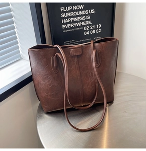 Detail of vintage dark brown faux leather tote bag with reinforced shoulder strap stitching