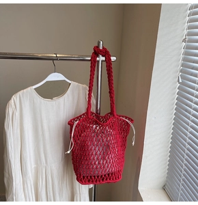 Detailed macro view of red crochet tote bag with mesh hollow design and drawstring liner