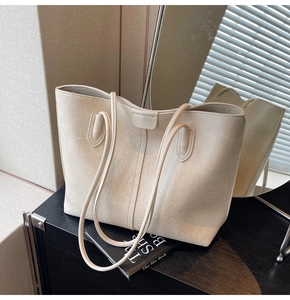 Detail of beige tote bag with retro textured synthetic leather and slim double straps