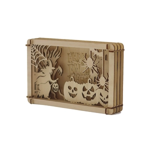 Macro view of multi-layered laser-cut wooden Halloween box with witch and pumpkin detail