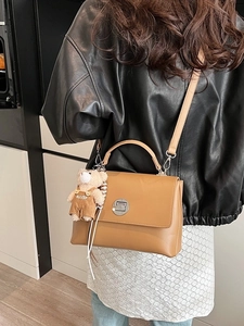 Vintage brown leather crossbody bag with metal twist lock and cute bear charm pendant