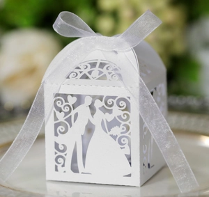 Laser-cut white wedding favor box with bride and groom silhouette and organza ribbon bow