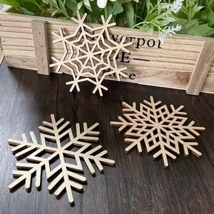 Three-piece laser-cut wooden snowflake coasters with natural texture for Xmas decor