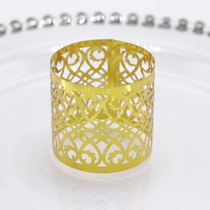 Detailed view of laser-cut gold metal napkin ring with heart and vine leaf pattern