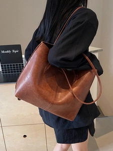Retro large capacity tote bag in vintage dark brown PU leather shown on shoulder