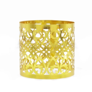 Macro detail of golden hollow napkin ring featuring elegant symmetrical vine patterns
