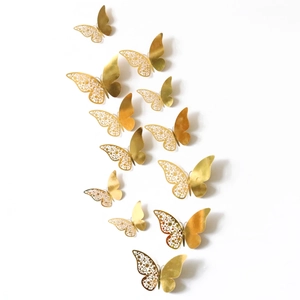 Detailed view of 12pcs gold 3D butterflies with hollow floral patterns on white wall