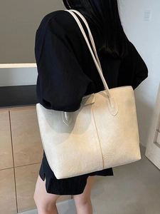 Minimalist beige large capacity tote bag worn by a model in a cozy interior setting