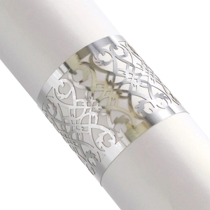Close-up of laser-cut silver napkin rings with intricate European hollow floral patterns