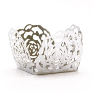 Close-up of laser-cut rose hollow cupcake wrapper in silver white mirror paper