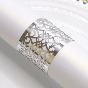 Detailed view of silver laser-cut napkin ring with intricate floral scroll patterns
