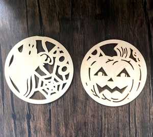 Close-up of Halloween laser-cut wooden coasters with ghost, Boo, and pumpkin designs