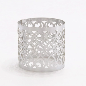 Detail of silver hollow metal napkin ring with laser-cut floral filigree pattern