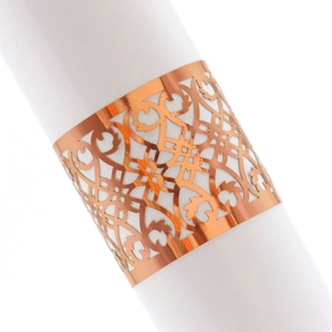 Macro shot of laser-cut napkin ring in rose gold finish with intricate hollow patterns
