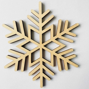 Detailed laser-cut snowflake wooden coaster with natural grain and scorched edges