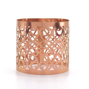 Detail of rose gold hollow laser-cut napkin ring with intricate vine leaf pattern