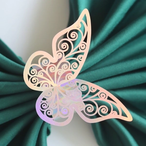 Holographic laser-cut butterfly napkin ring with intricate wing patterns on green satin