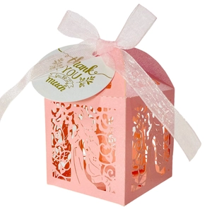 Pink laser-cut candy gift box with hollow vine patterns and a silk ribbon bow