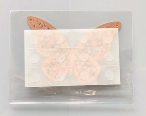 Close-up of laser-cut 3D rose gold butterfly wall sticker with adhesive dots