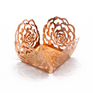 Detail of rose gold laser-cut hollow rose pattern cake wrapper for wedding decoration