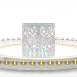 Close-up of laser-cut iridescent napkin ring with hollow patterns on white plate