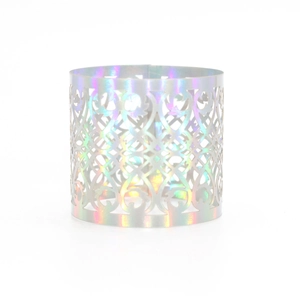 Detail of laser-cut iridescent silver napkin ring with elegant floral scroll patterns