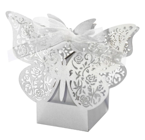Close-up of laser-cut butterfly wedding favor box with intricate rose patterns and silk ribbon