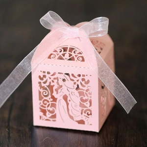 Détail de la boîte à bonbons rose découpée au laser avec silhouette et ruban en organza