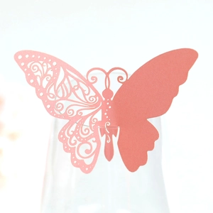 Detail of pink laser-cut butterfly place card with hollow pattern on wine glass