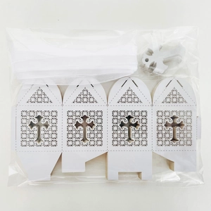 Flat pack of laser cut white favor boxes with cross pattern and ribbons for baptism