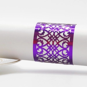 Detail of purple laser-cut napkin ring featuring intricate geometric hollow patterns