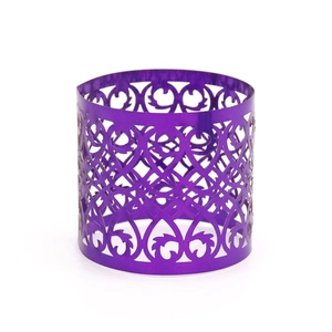 Macro view of purple laser-cut metal napkin ring with elegant heart patterns