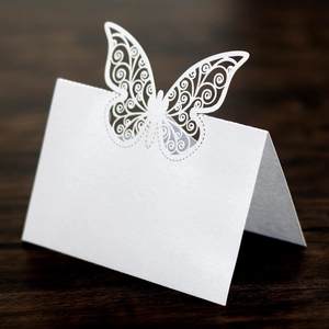 Gros plan du marque-place papillon découpé au laser avec motifs sur papier cartonné blanc