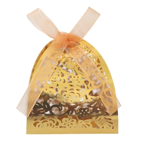 Détail de découpe laser florale sur boîte cadeau dorée avec ruban en organza