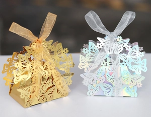 Close-up of gold and silver butterfly hollow candy boxes with laser-cut lace and ribbons
