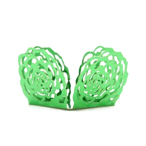 Detail of laser-cut emerald green lace paper cupcake wrapper with floral rose pattern