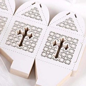 Laser-cut white wedding favor boxes with geometric floral patterns for party candies