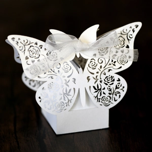 Detailed laser-cut butterfly wedding favor box with intricate rose patterns and silver ribbon