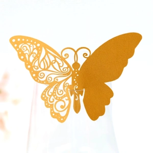 Detailed laser-cut hollow butterfly place card in gold finish on wine glass rim