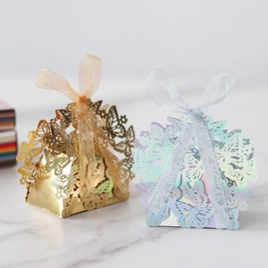 Detail of laser-cut butterfly gift boxes with gold mirror finish and ribbon closure