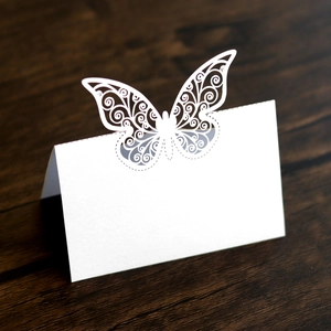 Détail de marque-place papillon découpé au laser avec motifs élégants sur bois sombre