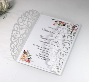 Detail of laser-cut floral wedding invitation with colorful inner card and intricate patterns